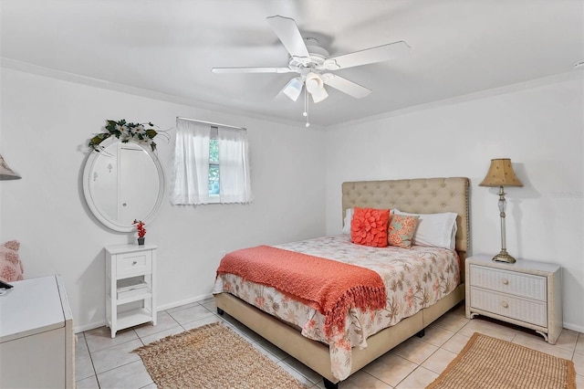 tiled bedroom with ornamental molding and ceiling fan