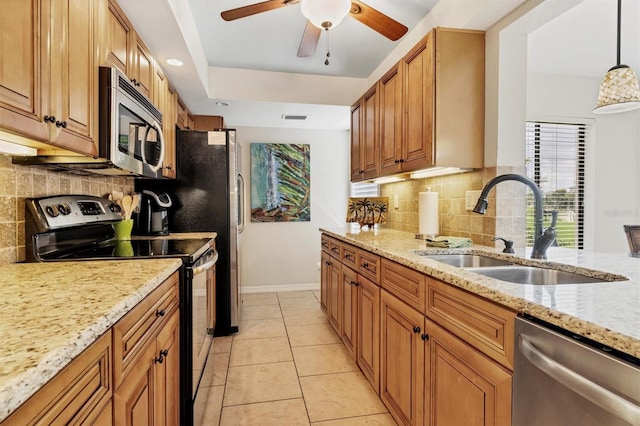 kitchen with ceiling fan, stainless steel appliances, decorative light fixtures, backsplash, and sink