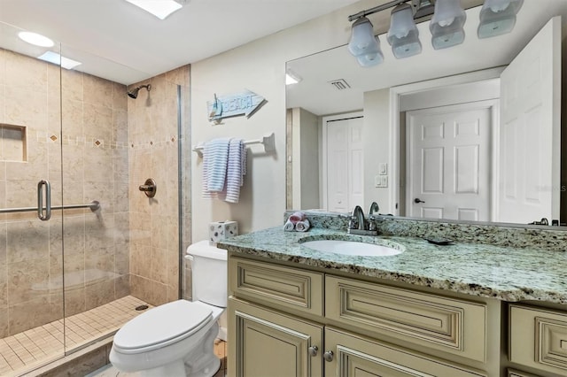 bathroom with an enclosed shower, toilet, and vanity with extensive cabinet space