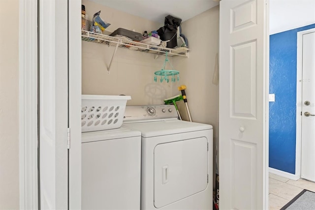 washroom featuring washing machine and dryer and light tile flooring