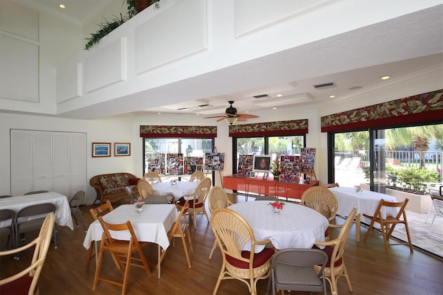 dining room with crown molding, wood-type flooring, and ceiling fan