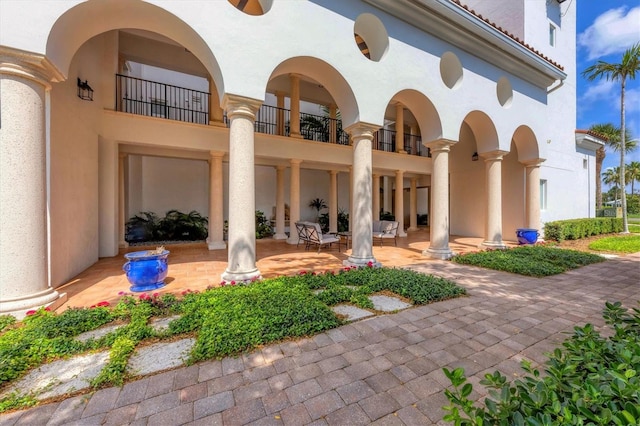 rear view of house featuring a patio area and a balcony