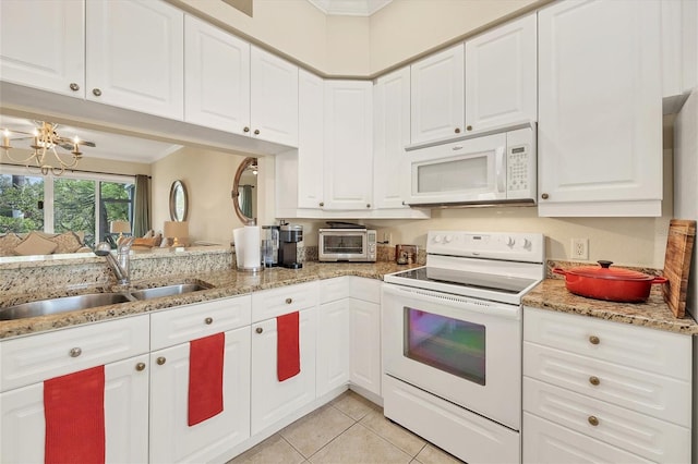 kitchen with white cabinetry, sink, white appliances, and a notable chandelier