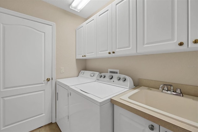 washroom with washer and clothes dryer, cabinets, and sink