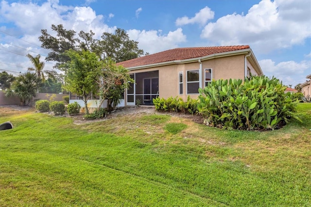 back of property with a sunroom and a yard