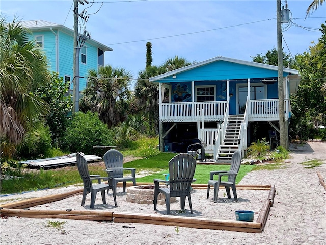 rear view of property featuring a fire pit