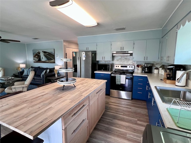 kitchen featuring dark hardwood / wood-style flooring, stainless steel appliances, tasteful backsplash, ceiling fan, and blue cabinets