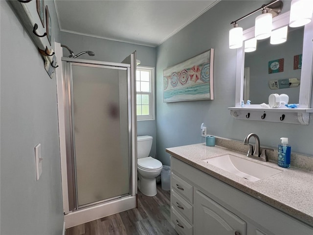 bathroom featuring crown molding, an enclosed shower, hardwood / wood-style floors, vanity, and toilet