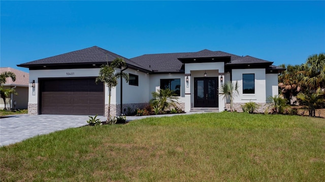 prairie-style house featuring a garage and a front yard