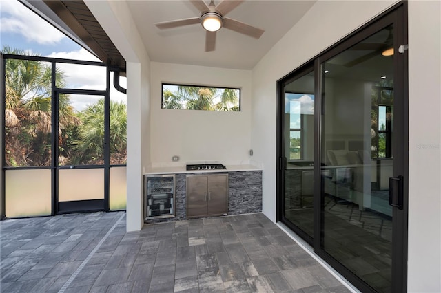 unfurnished sunroom featuring wine cooler and ceiling fan