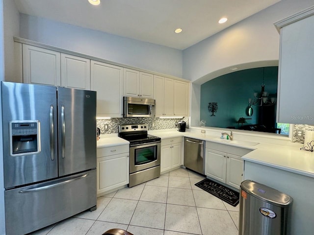 kitchen featuring appliances with stainless steel finishes, backsplash, and light tile flooring