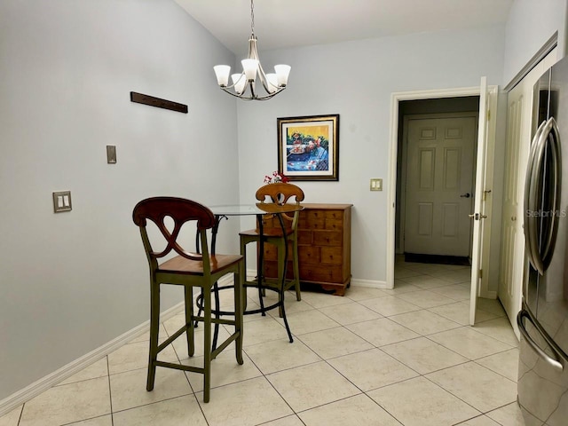 dining area featuring a notable chandelier, lofted ceiling, and light tile floors