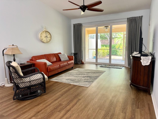 living room with wood-type flooring and ceiling fan