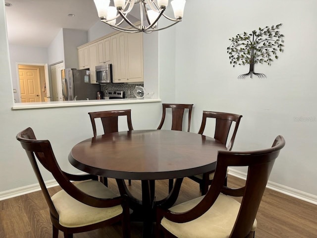 dining area with a chandelier and wood-type flooring