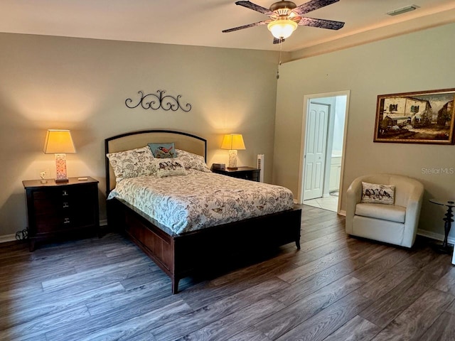 bedroom with dark wood-type flooring, ceiling fan, and ensuite bath