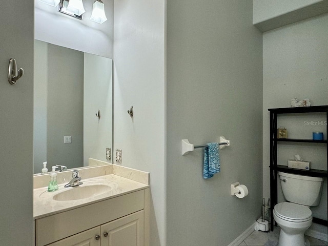 bathroom featuring tile floors, vanity, and toilet