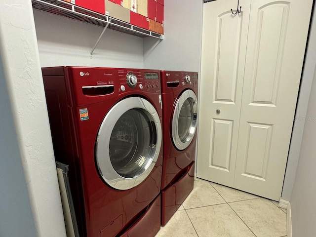 laundry area with washer and dryer and light tile floors