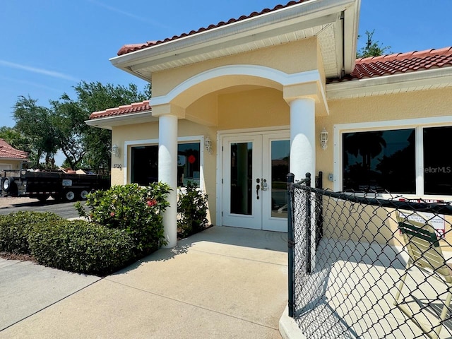 view of exterior entry with a garage and french doors