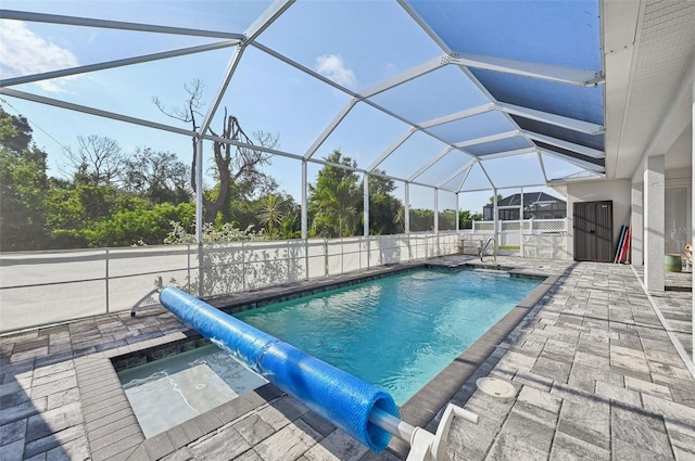 view of swimming pool featuring glass enclosure and a patio area