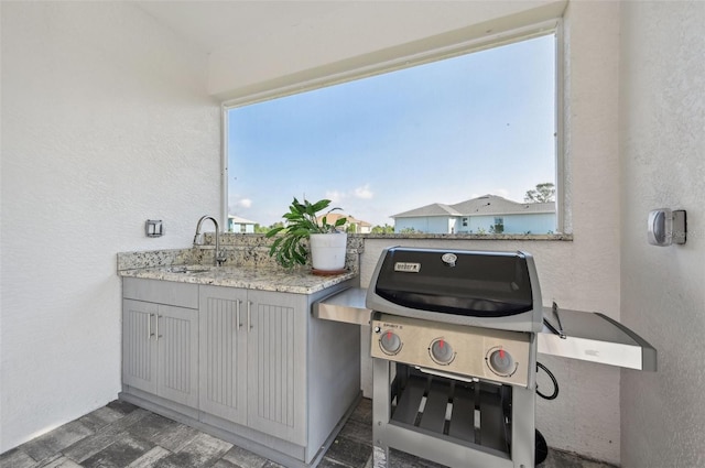 view of patio with grilling area and sink