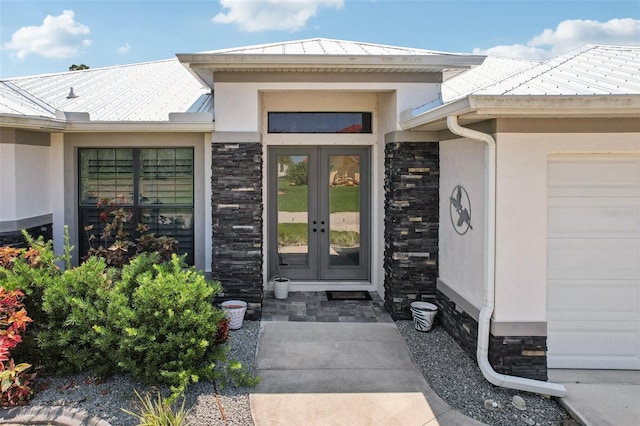 view of exterior entry with french doors and a garage