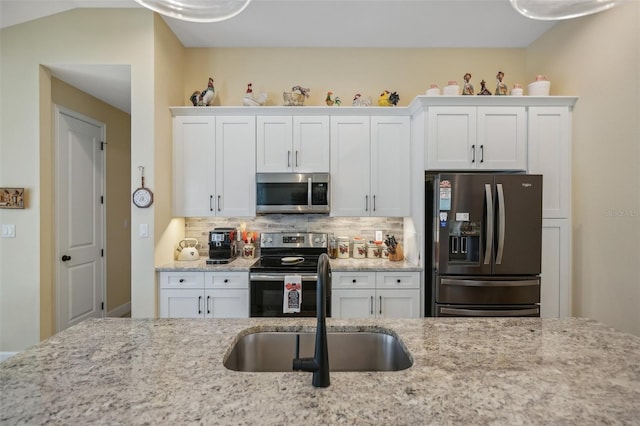 kitchen with tasteful backsplash, white cabinetry, sink, and appliances with stainless steel finishes