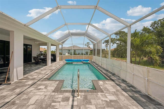 view of swimming pool with a patio, ceiling fan, and a lanai