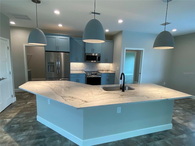 kitchen with an island with sink, stainless steel appliances, tasteful backsplash, and sink