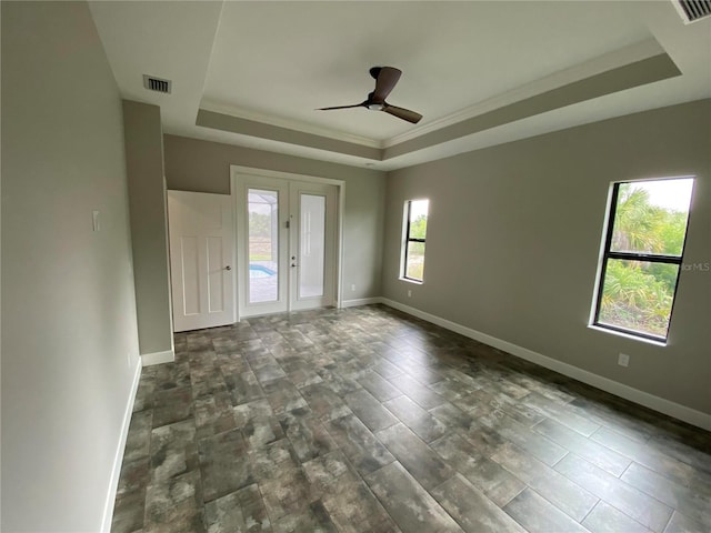 unfurnished room featuring ceiling fan, dark hardwood / wood-style flooring, a tray ceiling, and french doors