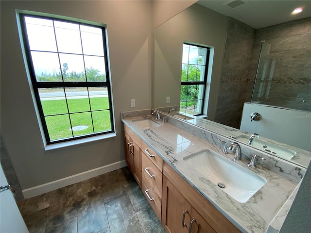 bathroom featuring dual vanity, tile flooring, and a wealth of natural light