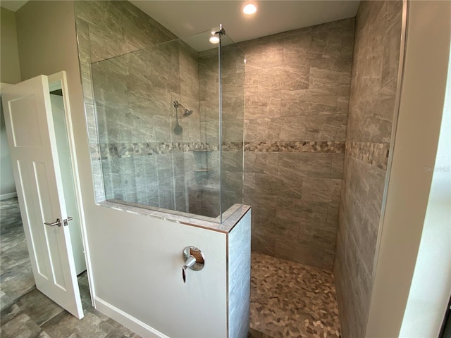 bathroom with tile flooring and tiled shower