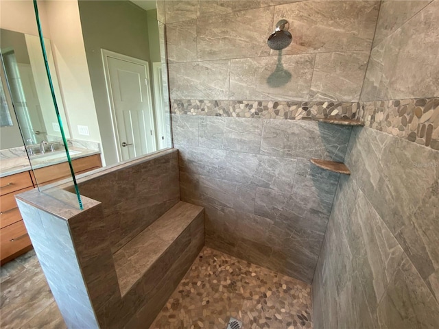 bathroom with a tile shower and oversized vanity