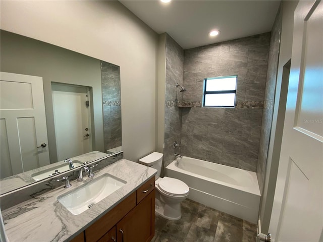 full bathroom featuring tile floors, tiled shower / bath, vanity, and toilet