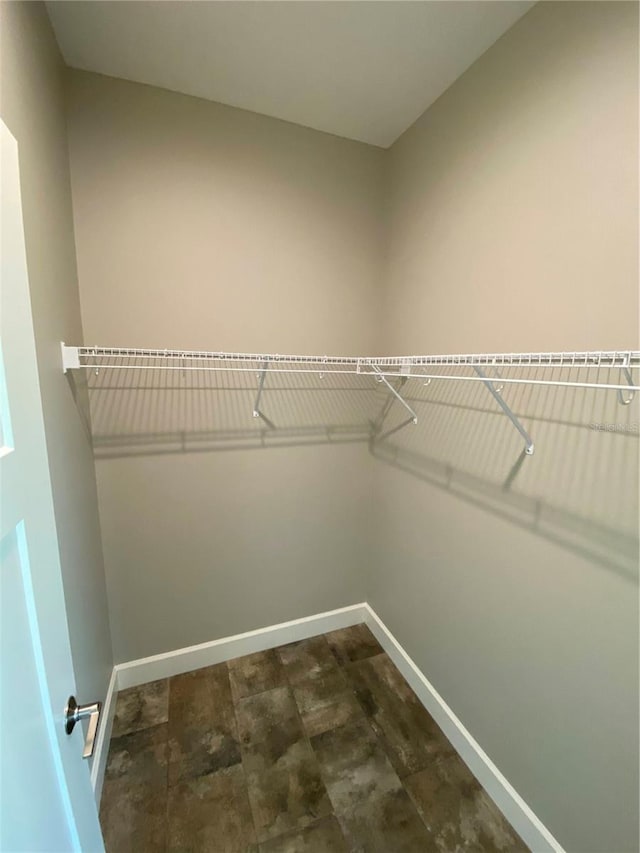 spacious closet featuring dark tile floors