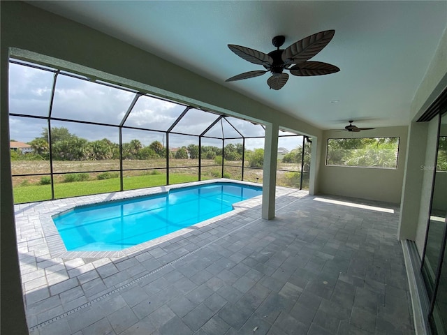 view of swimming pool featuring a patio, glass enclosure, and ceiling fan