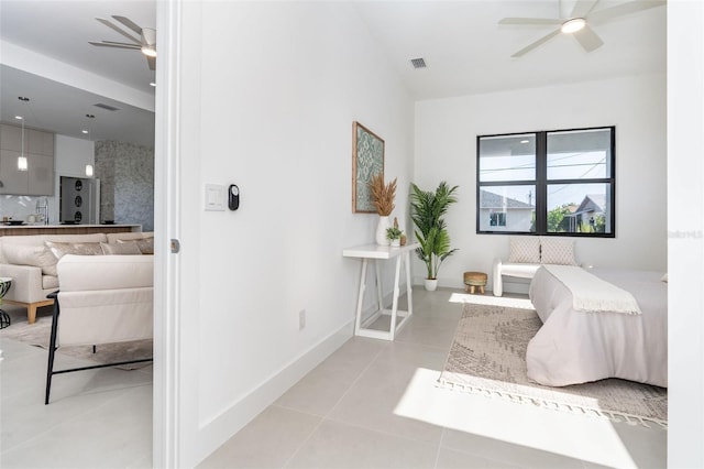 interior space with light tile patterned floors, baseboards, visible vents, ceiling fan, and ensuite bathroom