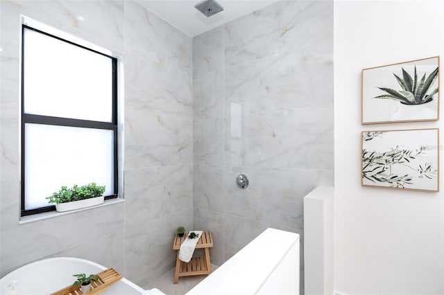 bathroom with a freestanding tub and a tile shower