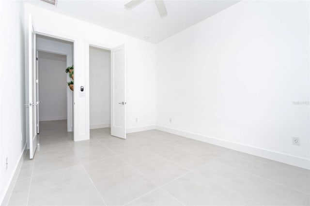 unfurnished bedroom featuring baseboards, a ceiling fan, and light tile patterned flooring