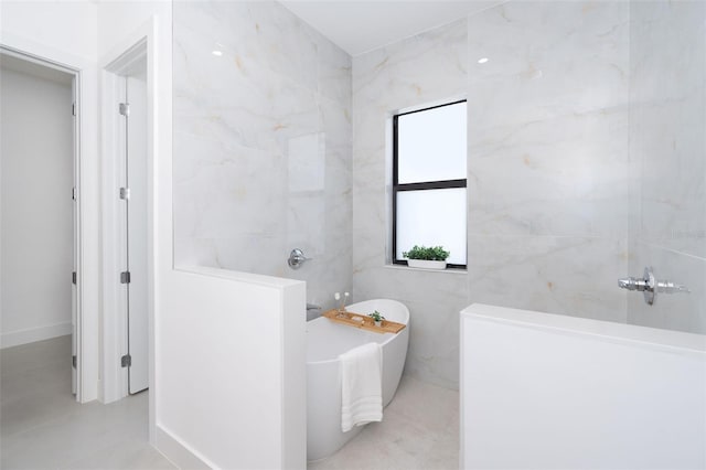 full bathroom featuring a soaking tub and tile walls