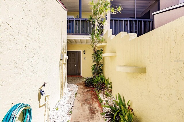 view of exterior entry featuring a balcony