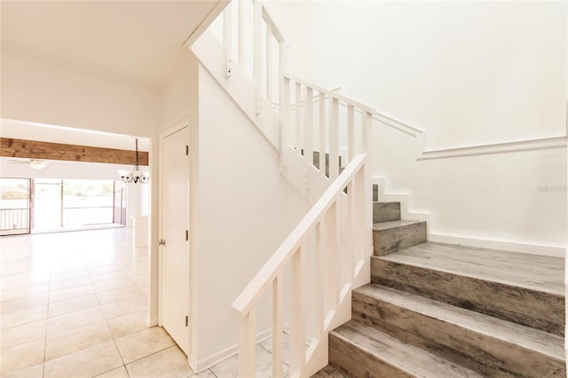 stairs featuring tile patterned flooring and a chandelier