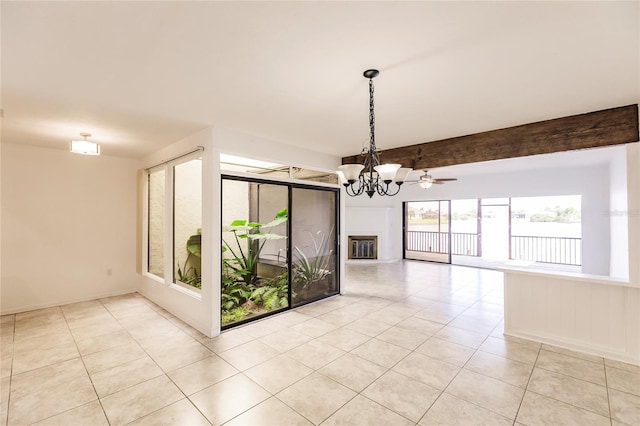 tiled spare room featuring beamed ceiling and ceiling fan with notable chandelier