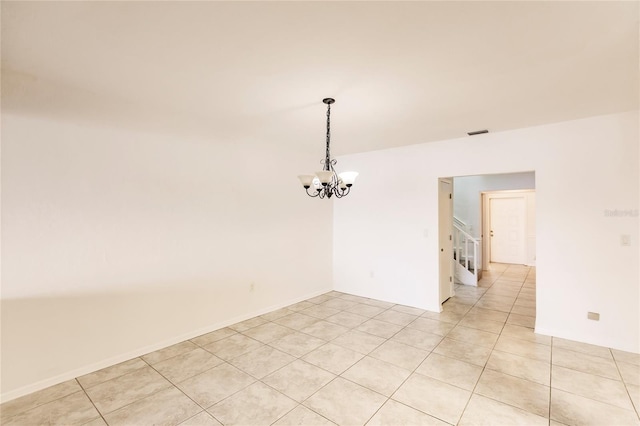 tiled empty room with a notable chandelier