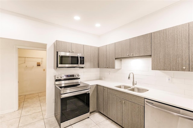 kitchen featuring decorative backsplash, sink, light tile patterned floors, and stainless steel appliances