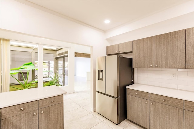 kitchen with stainless steel fridge, backsplash, and light tile patterned floors