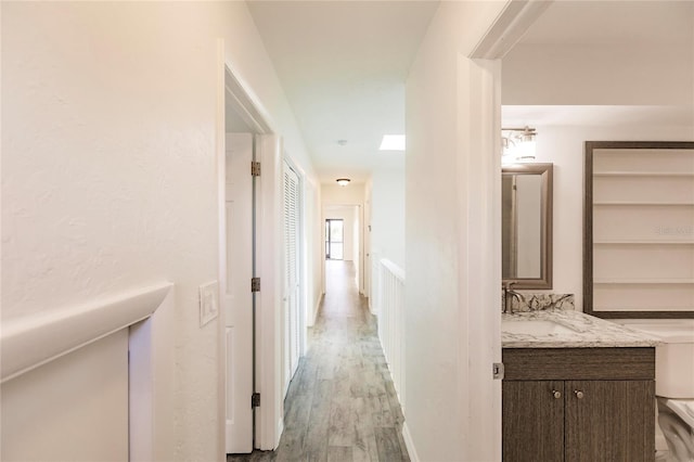 hall with light hardwood / wood-style floors and sink