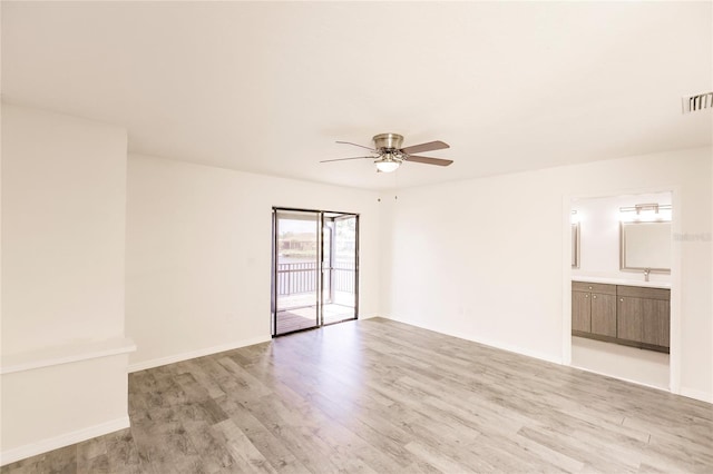 spare room with ceiling fan and light wood-type flooring