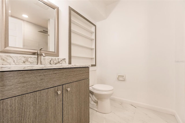 bathroom featuring built in shelves, vanity, and toilet