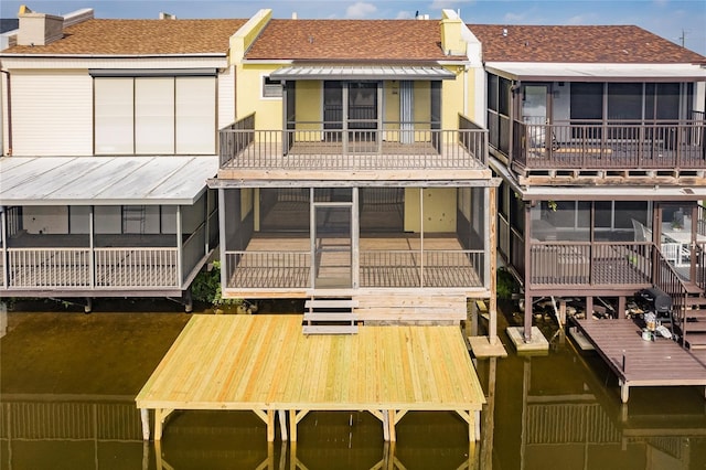 rear view of house featuring a sunroom