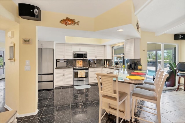 tiled dining room featuring beamed ceiling, a high ceiling, and sink